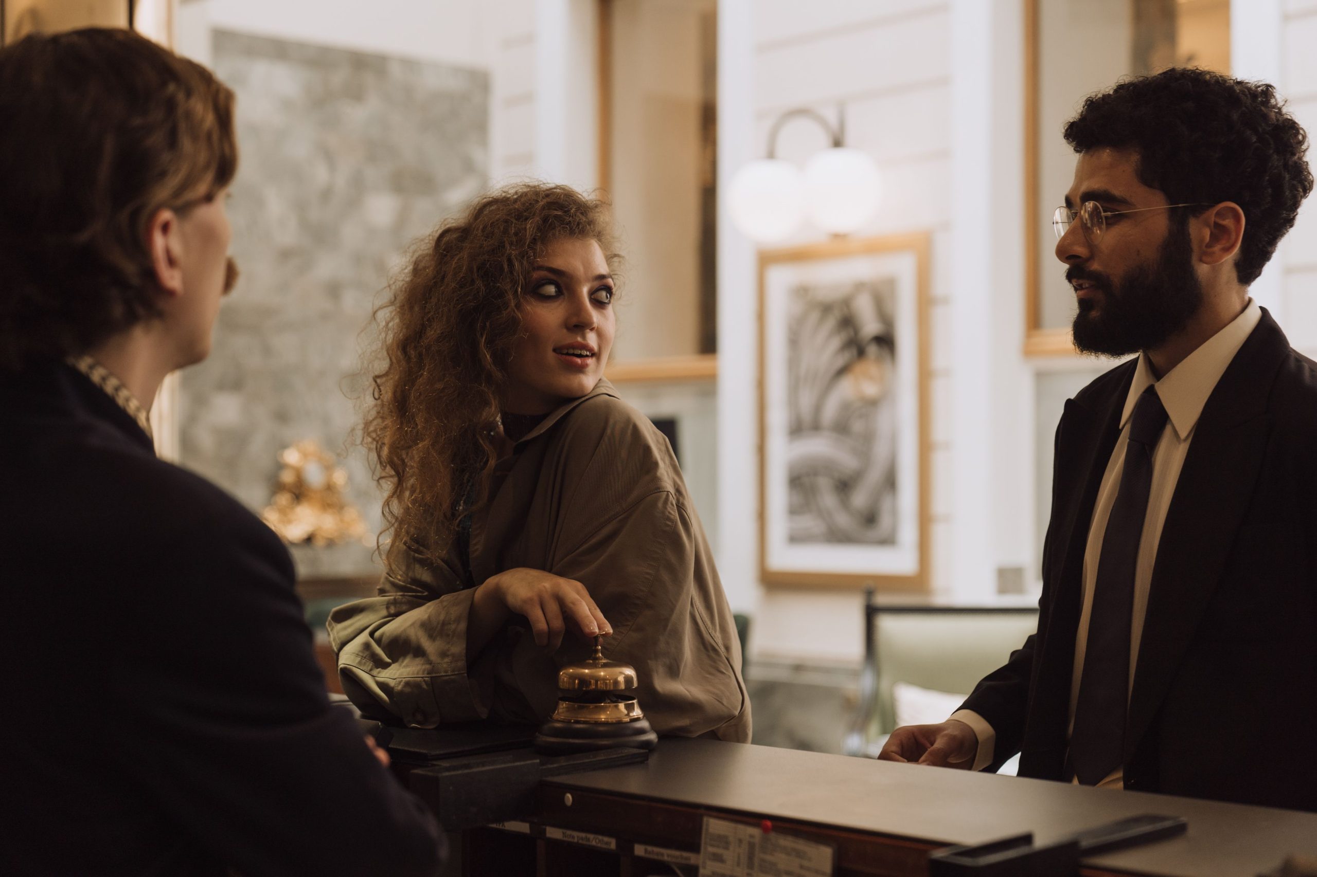 Hotel staff welcoming guests at a luxury reception desk with attentive, polished service.