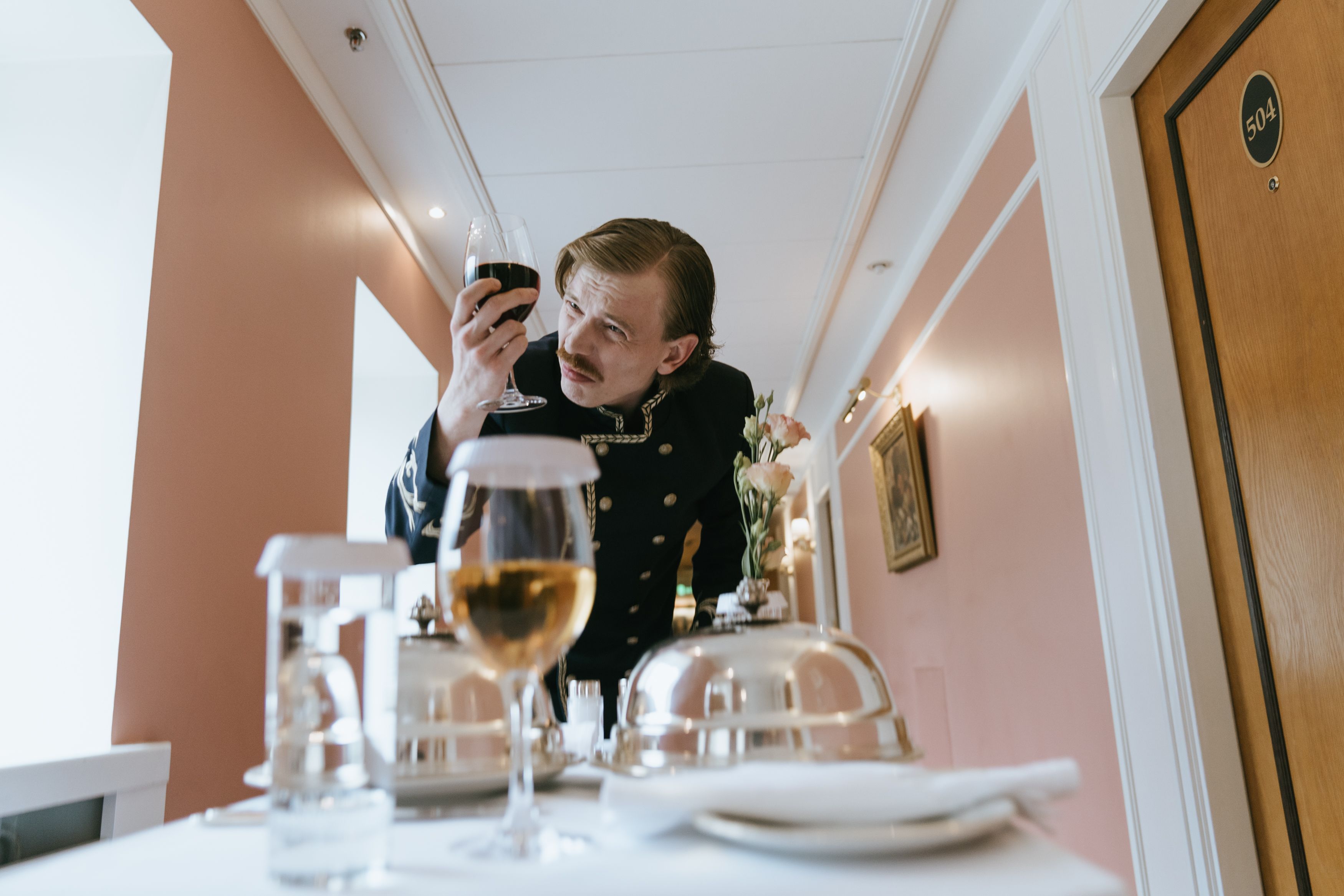 Hotel concierge preparing a drink on a trolley, illustrating thoughtful and anticipatory luxury service.